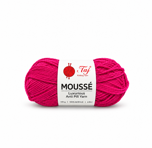 A skein of bright pink Moussé anti-pill yarn with a white paper label from Taj Knitting Yarn, shown on a plain white background.