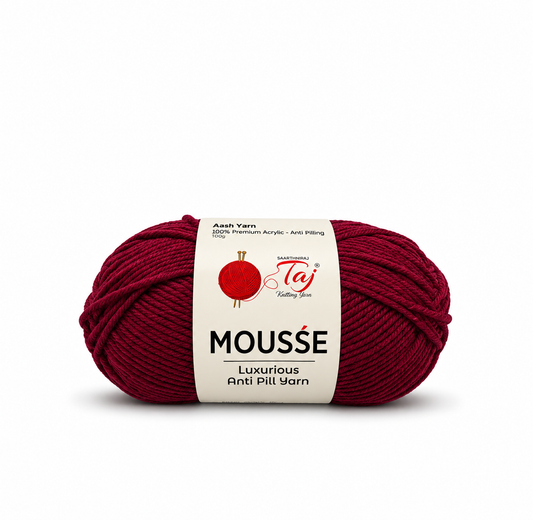 A skein of deep burgundy yarn with a white paper label that reads 'MOUSSE' and shows the Taj brand logo, photographed on a clean white background.