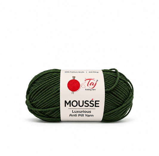 A skein of dark forest green yarn with a white paper label that reads 'MOUSSE Luxurious Anti Pill Yarn' and shows the Taj Knitting Son logo, on a plain white background.