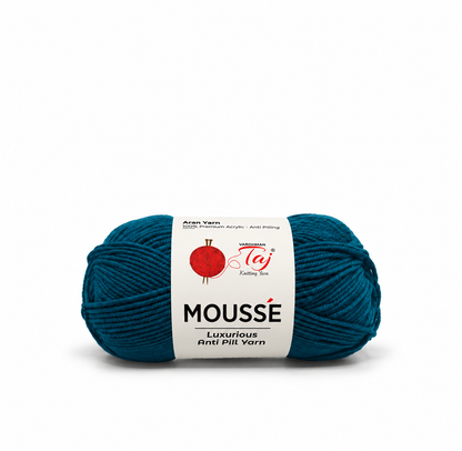 A single skein of Mousse Luxurious Anti Pill Yarn in a deep teal blue color, wrapped with a white paper label showing the brand logo.