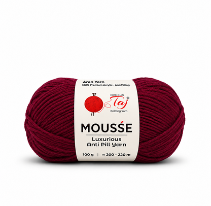 A single skein of Moussé Anti Pill Yarn in a deep burgundy red color, featuring a white paper label with the brand logo 'Taj Knitting Yarn'.