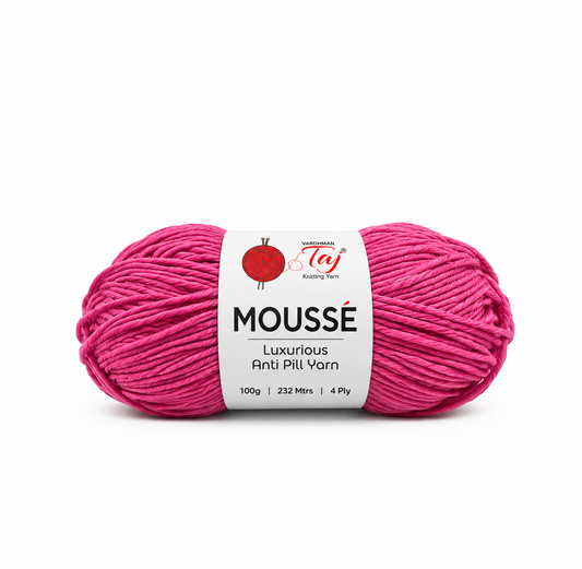 A skein of bright pink Moussé luxurious anti-pill yarn with a white paper label, shown on a clean white background.