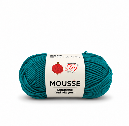A skein of Wackenroder MOUSSE Luxurious Anti Pilling yarn in a deep teal color, wrapped with a white paper label showing the brand logo.