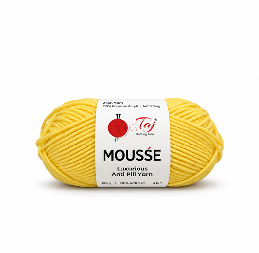A skein of yellow Mousse Anti Pill Yarn by Taj Knitting Yarn, wrapped in a white paper label, on a clean white background.