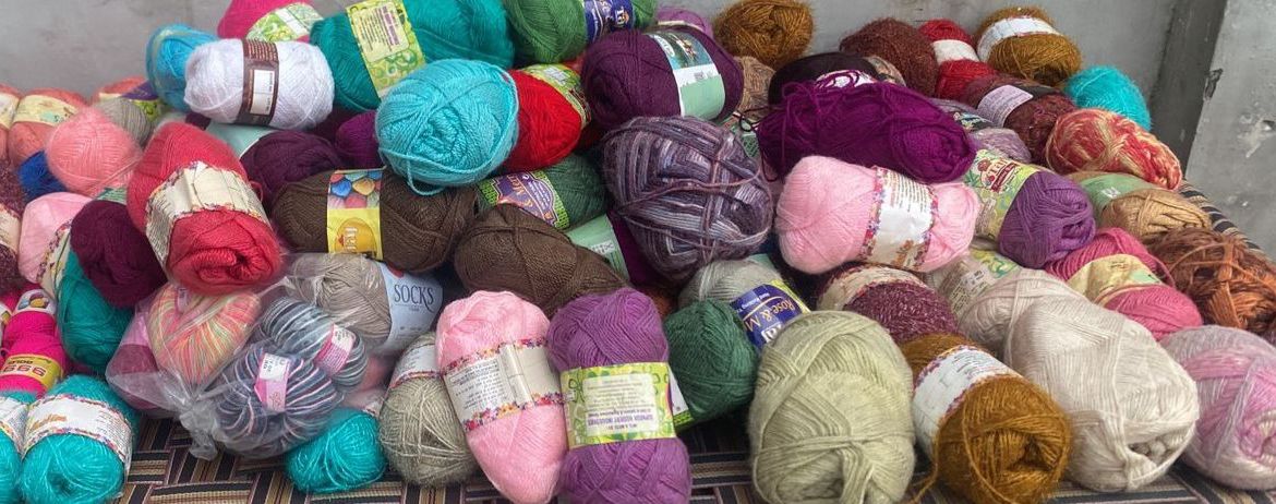 Assorted colorful yarn balls on a metal surface