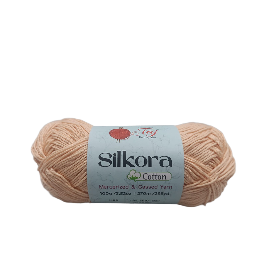 Ball of beige yarn with a Silkora Cotton label on a white background