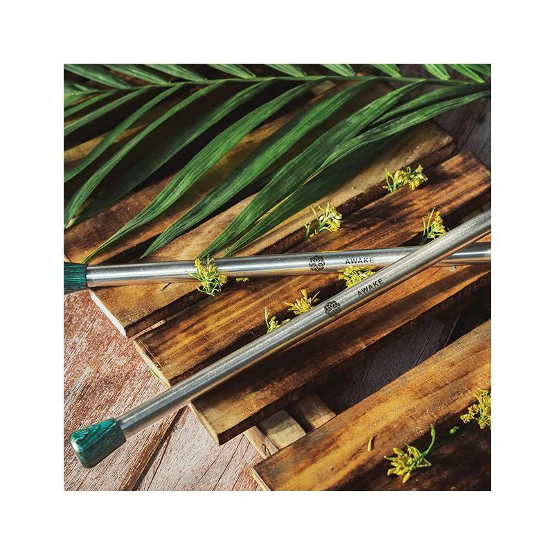 Two metal rods with green tips on a wooden surface with leaves
